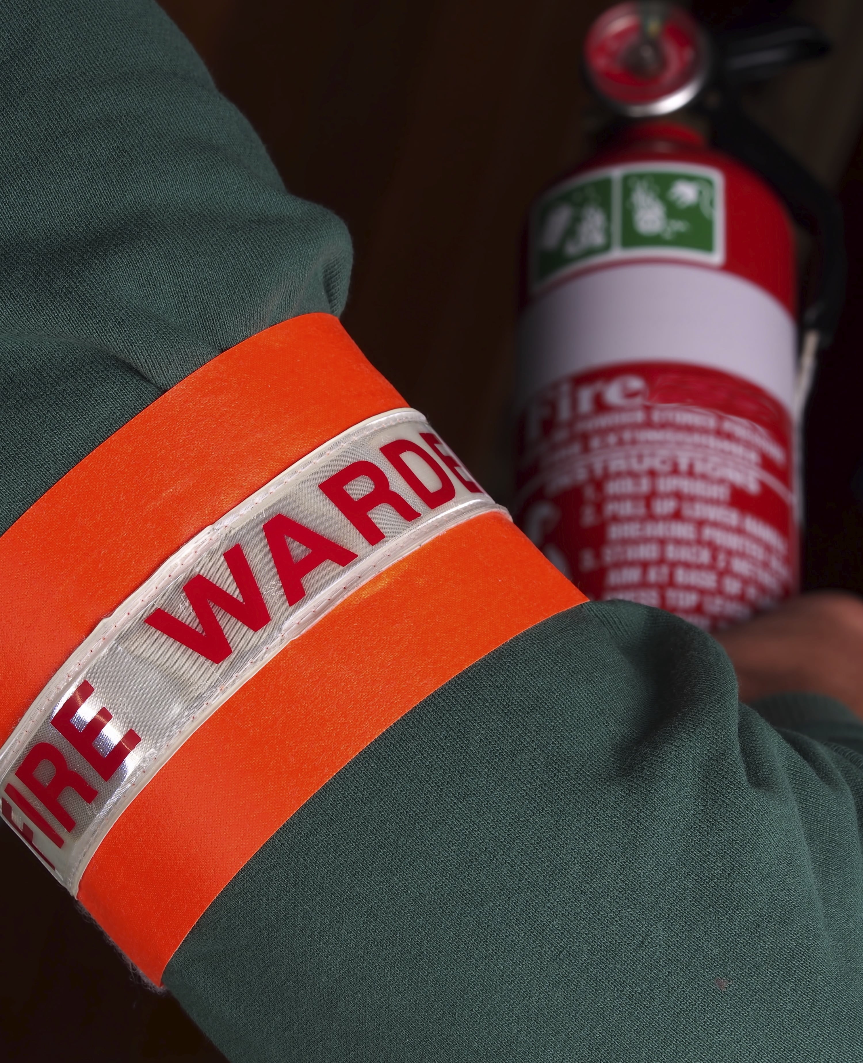 sleeve with fire warden arm band holding fire extinguisher