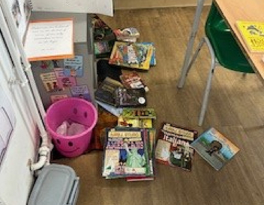 piles of books i a walkway in a classrroom