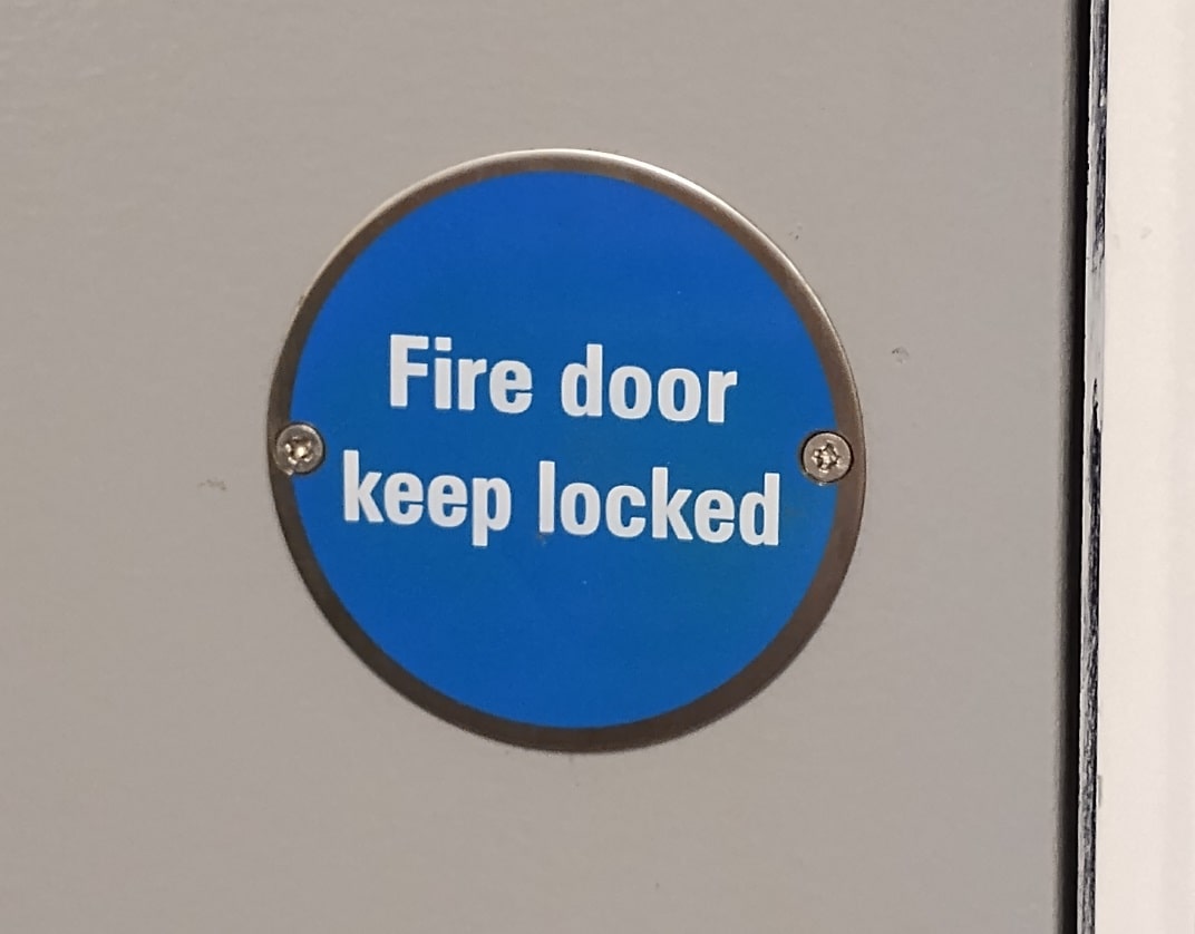fire door keep locked sign on a grey fire door