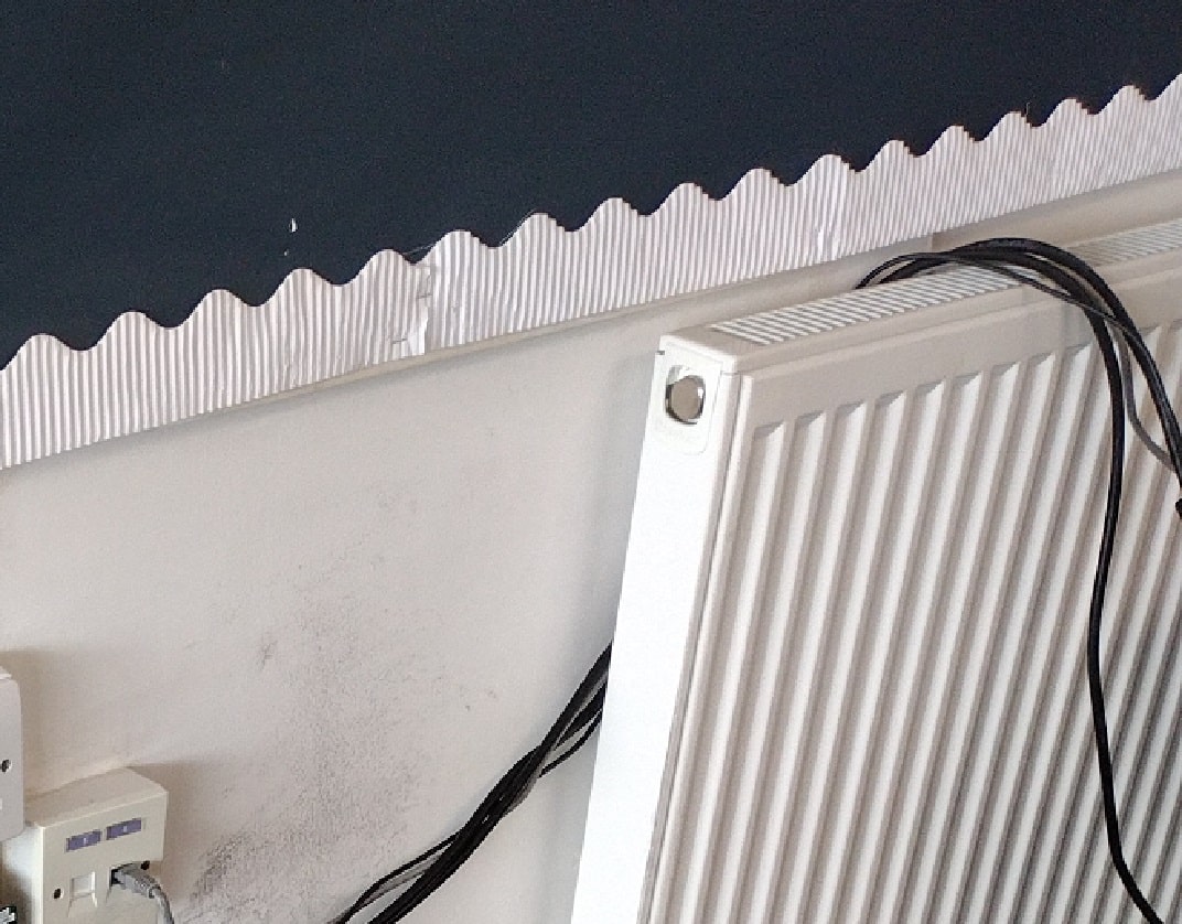 black electrical flexes handing over a radiator