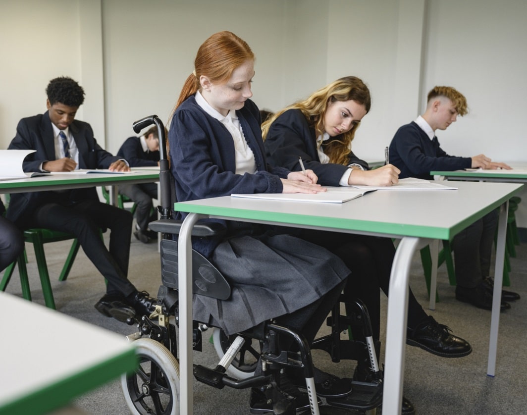 girl sitting in her wheelchair working at her desk