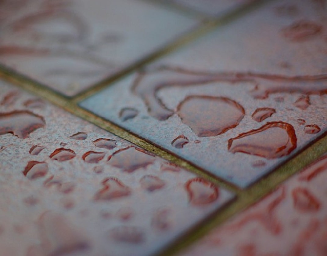 cermanic red tiles floor with water spilt on its surface