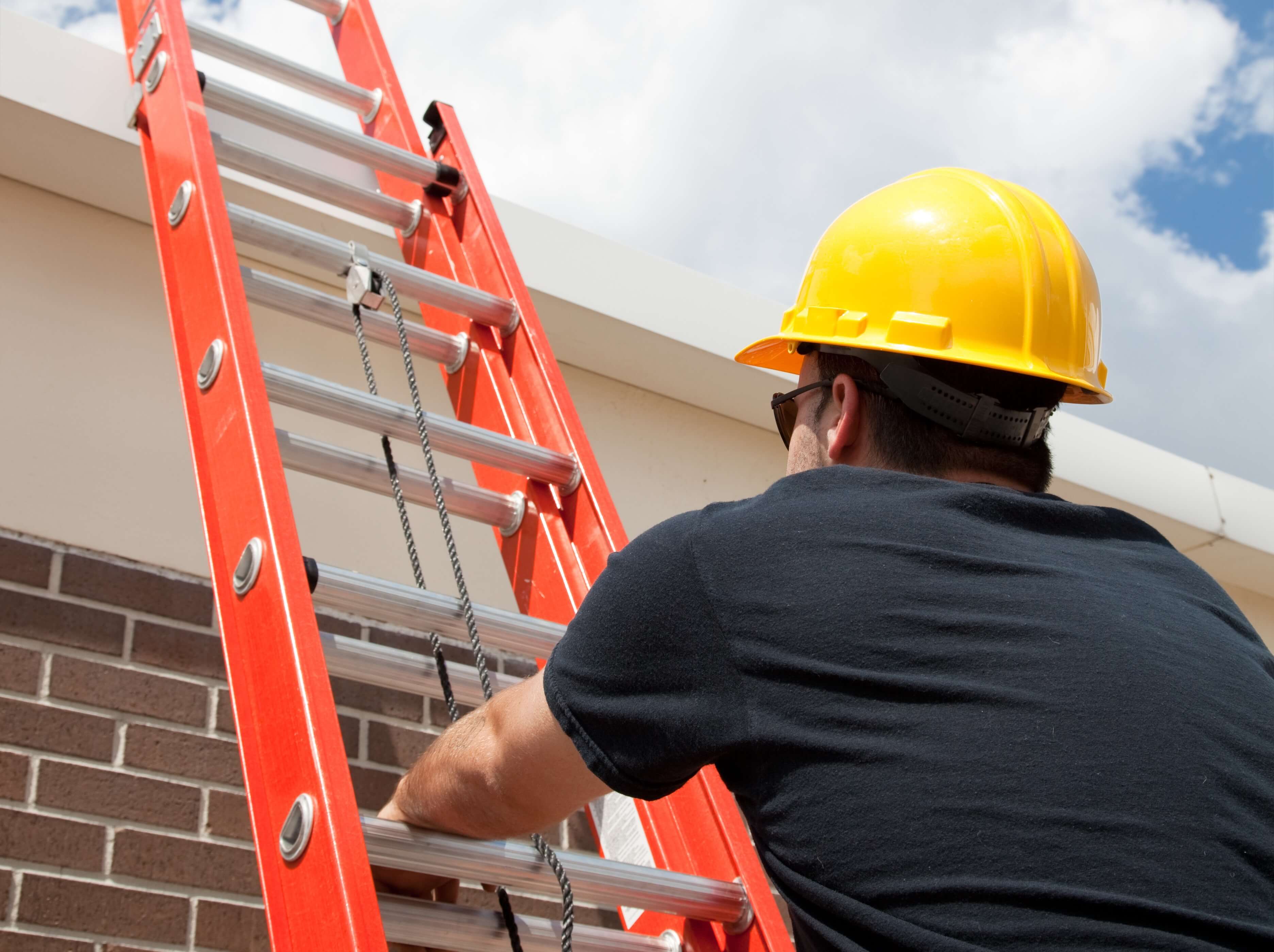 man climbing an orange rope-operated extension ladder